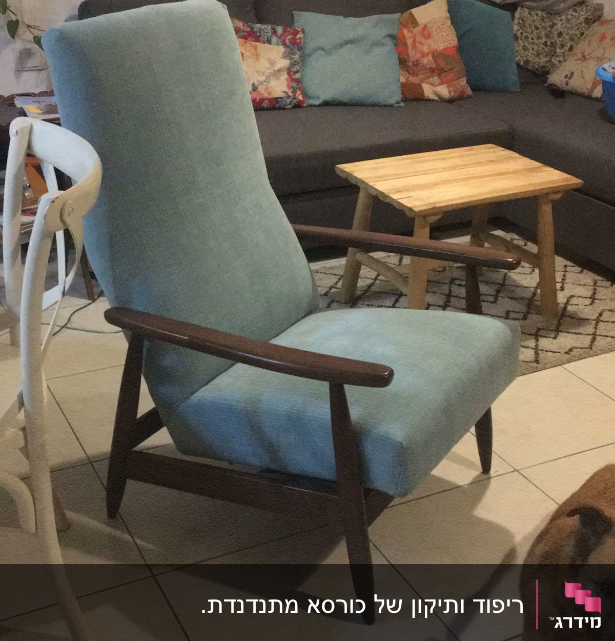 כורסה מרופדת בבד כחול בהיר עם מסגרת עץ כהה